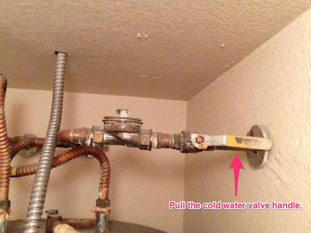 Pull the valve handle on the cold water inlet line to slow the leak